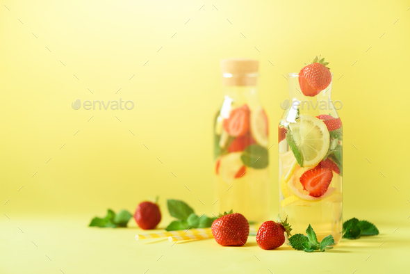Strawberry detox water with mint, lemon on yellow background. Citrus lemonade. Banner. Summer fruit - Stock Photo - Images