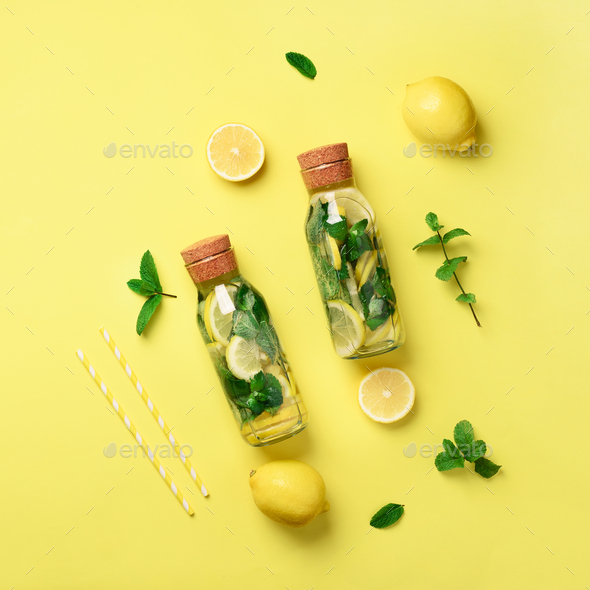 Bottle of detox water with mint, lemon on yellow background. Flat lay. Square crop. Citrus lemonade - Stock Photo - Images
