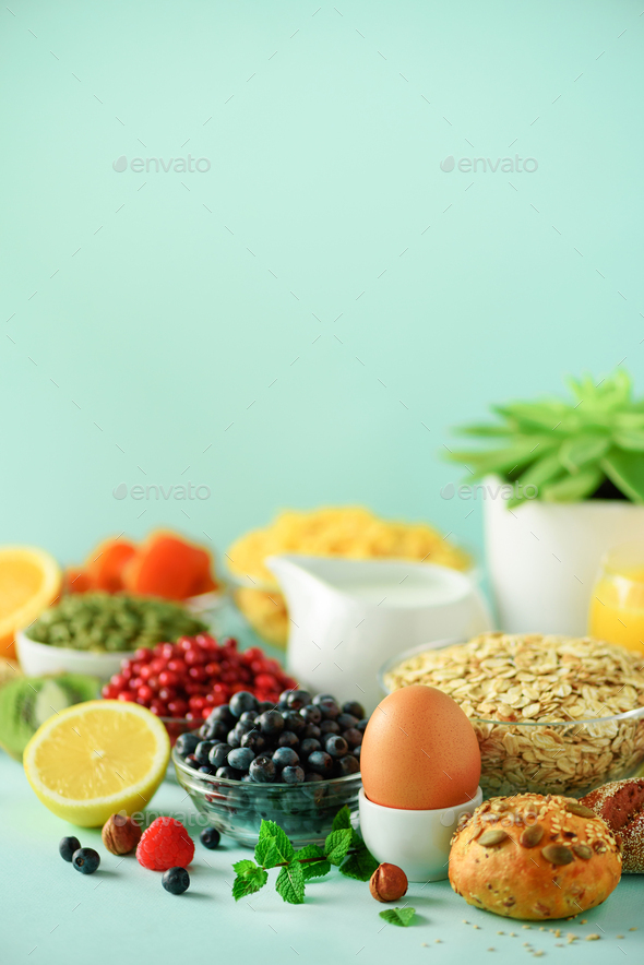 Corn flakes with milk, fresh berries, yogurt, boiled egg, nuts, fruits, orange, banana, peach for - Stock Photo - Images