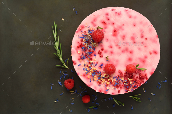 Delicious raspberry cake with fresh berries, rosemary and dry flowers on dark vintage background - Stock Photo - Images
