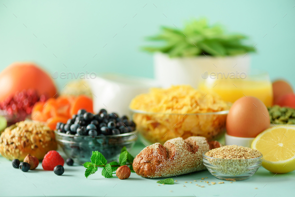 Delicious breakfast ingredients. Soft boiled egg, oat flakes, nuts, fruits, berries, milk, yogurt - Stock Photo - Images