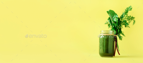 Banner of smoothie with beet greens and carrot tops on yellow background, copy space. Summer vegan - Stock Photo - Images