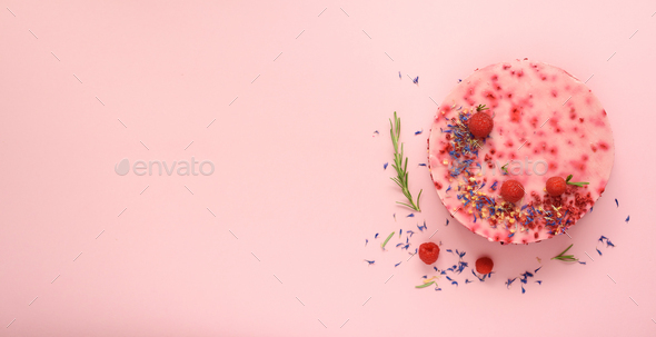 Delicious raspberry cake with fresh berries, rosemary and dry flowers on pink background. Copy space - Stock Photo - Images