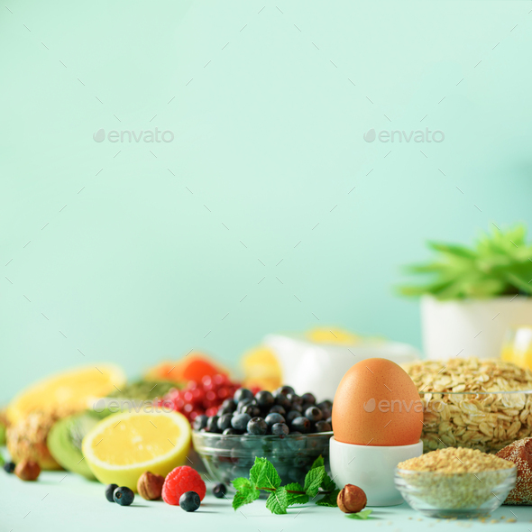 Healthy breakfast ingredients. Square crop. Oat and corn flakes, eggs, nuts, fruits, berries, toast - Stock Photo - Images