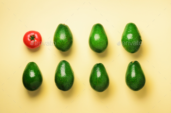 Green sliced avocado and red tomato on blue and yellow background. Top view. Pop art design - Stock Photo - Images