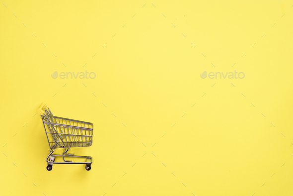 Shopping cart on yellow background. Minimalism style. Creative design. Top view with copy space - Stock Photo - Images