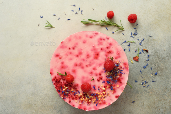 Delicious raspberry cake with fresh berries, rosemary and dry flowers on gray concrete background - Stock Photo - Images
