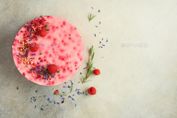 Delicious raspberry cake with fresh berries, rosemary and dry flowers on gray concrete background - Stock Photo - Images