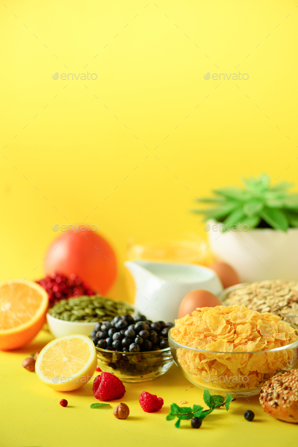 Corn cereal, muesli, milk, berries, orange juice, yogurt, boiled egg, nuts, fruits, banana, peach - Stock Photo - Images