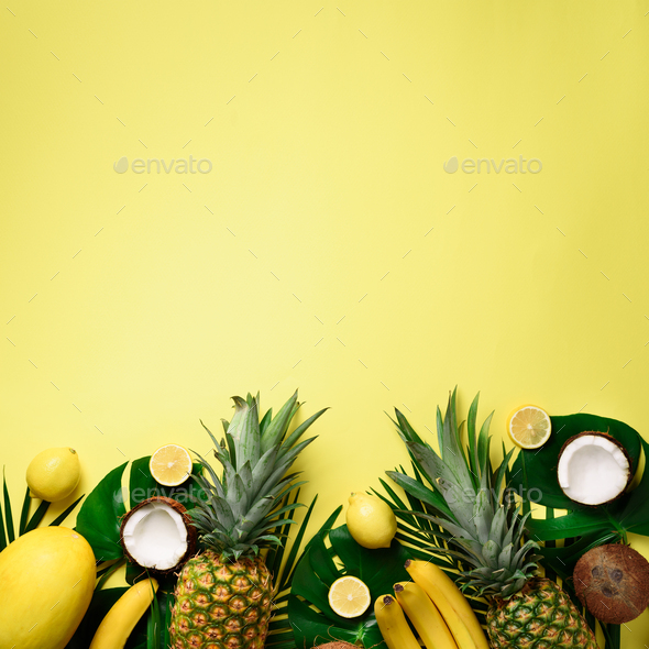 Exotic pineapples, ripe coconuts, banana, melon, lemon, tropical palm and green monstera leaves on - Stock Photo - Images