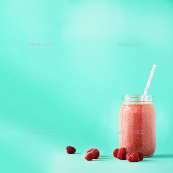 Glass of vegan smoothie with raspberries on blue background with copy space. Square crop. Summer - Stock Photo - Images