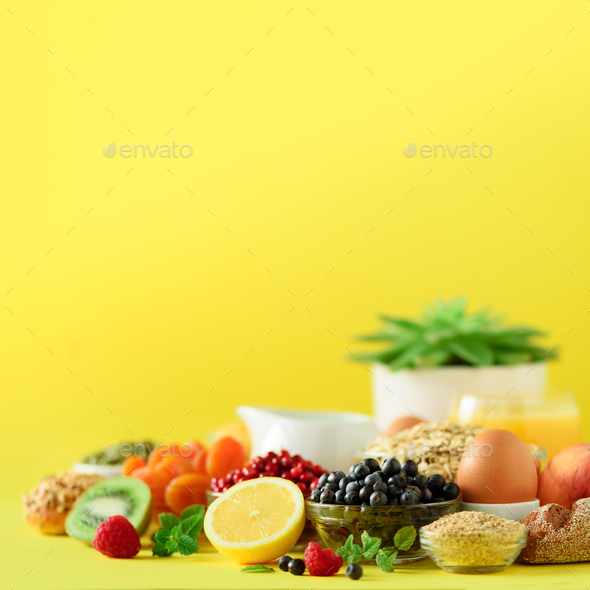 Organic breakfast ingredients. Square crop. Oat and corn flakes, eggs, nuts, fruits, berries, toast - Stock Photo - Images