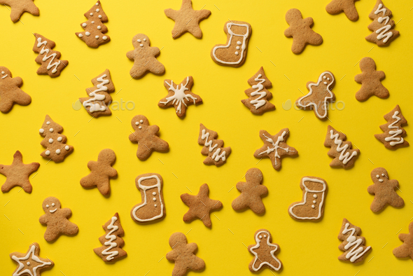 Homemade christmas cookies on yellow background. Pattern of gingerbread men, snowflake, star, fir - Stock Photo - Images