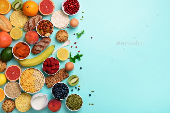 Organic food frame. Healthy breakfast ingredients. Oat and corn flakes, eggs, nuts, fruits, berries - Stock Photo - Images