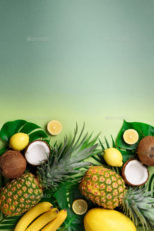Exotic pineapples, coconuts, banana, melon, lemon, tropical palm and monstera leaves on green - Stock Photo - Images