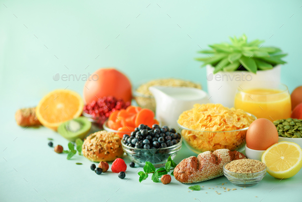 Corn cereal, muesli, milk, berries, orange juice, yogurt, boiled egg, nuts, fruits, banana, peach - Stock Photo - Images