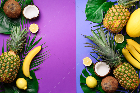 Exotic pineapples, coconuts, banana, melon, lemon, tropical palm and green monstera leaves on purple - Stock Photo - Images