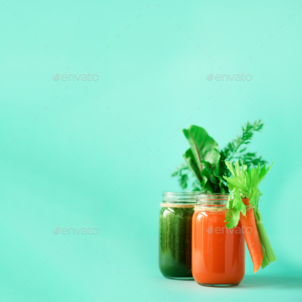 Healthy organic green and orange smoothies on blue background. Square crop. Detox drinks in glass - Stock Photo - Images