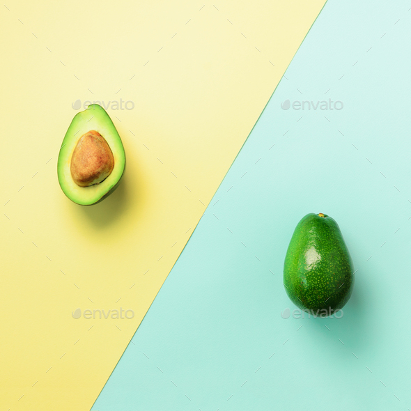 Avocado sliced with seed, whole fruit on blue and yellow background. Top view. Pop art design - Stock Photo - Images