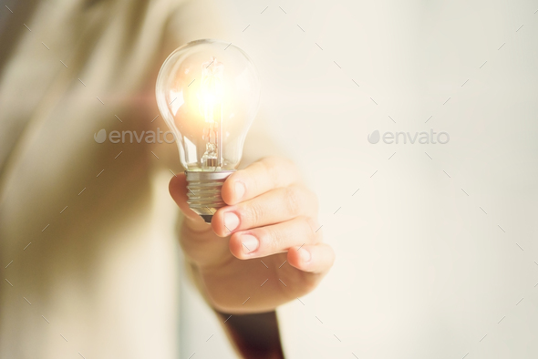 Woman hand holding light bulb on cream background with copy space. Creative idea, new business plan - Stock Photo - Images