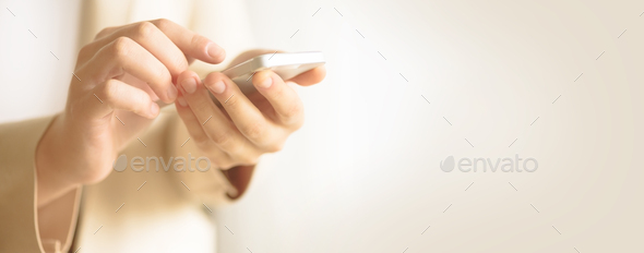 Woman hands hold cell phone on light cream background with copy space. Banner. Business, study - Stock Photo - Images