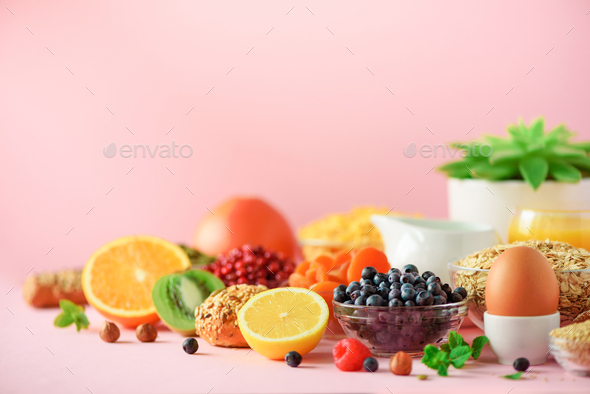 Breakfast served with soft boiled egg, oat flakes, nuts, fruits, berries, milk, yogurt, orange - Stock Photo - Images