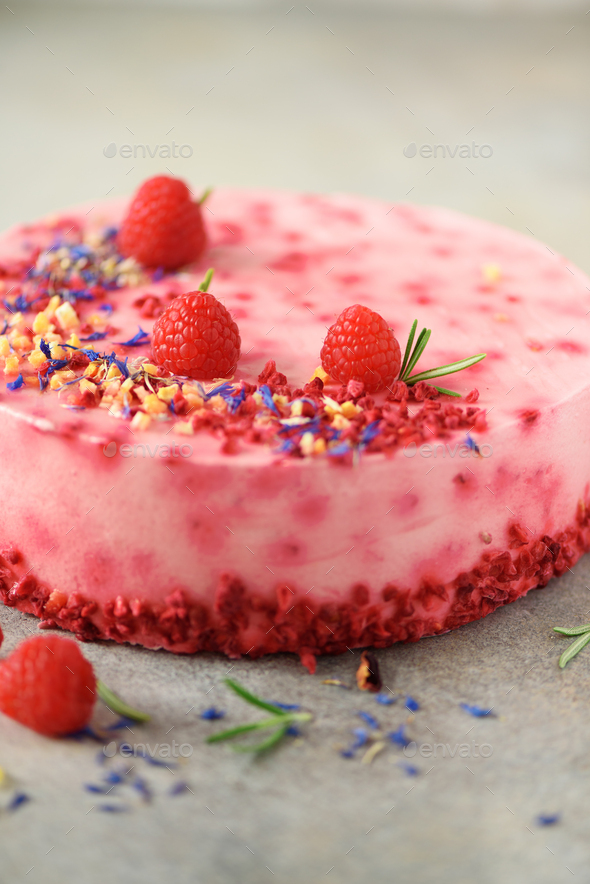 Delicious raspberry cake with fresh berries, rosemary and dry flowers on gray concrete background - Stock Photo - Images