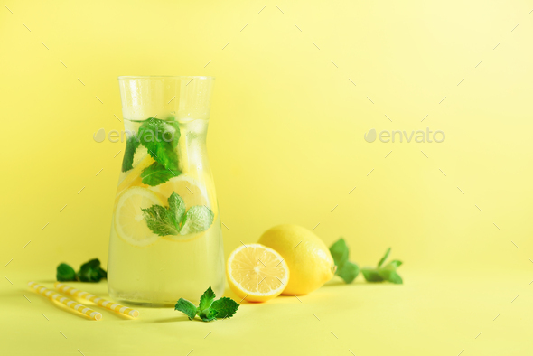 Detox water with mint, lemon on yellow background. Banner with copy space, sunlight bokeh. Citrus - Stock Photo - Images