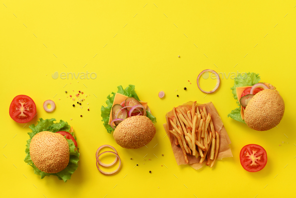 Fast food banner. Juicy meat burgers with beef, tomato, cheese, onion,  cucumber and lettuce on Stock Photo by jchizhe