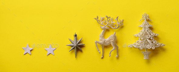 Silver Christmas decoration - deer, fir-tree, stars, cone on yellow background with copy space - Stock Photo - Images