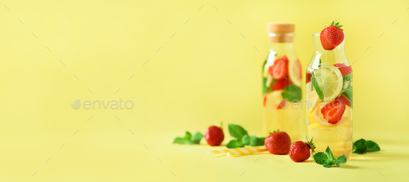 Strawberry detox water with mint, lemon on yellow background. Citrus lemonade. Banner. Summer fruit - Stock Photo - Images