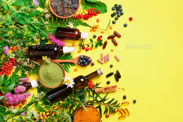 Alternative medicine. Holistic approach. Healing herbs and flowers over yellow background. Top view - Stock Photo - Images