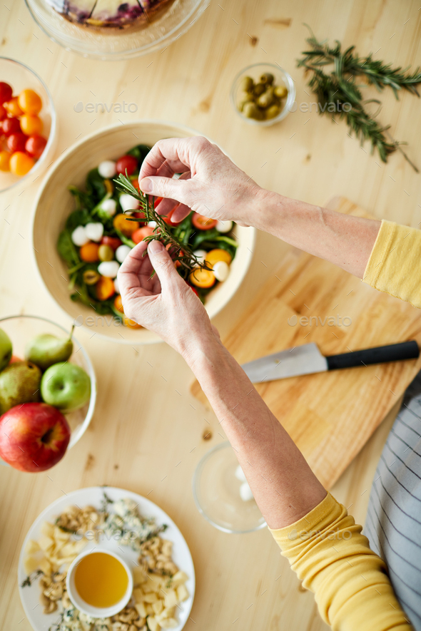 Adding rosemary into salad - Stock Photo - Images