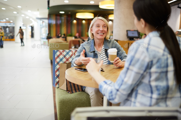 Happy woman drinking coffee with friend - Stock Photo - Images