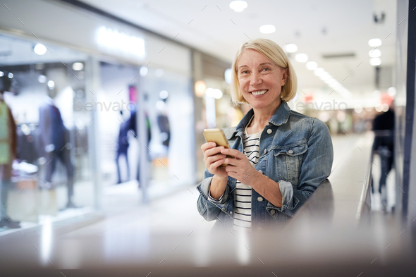 Sales consultant of clothing store texting sms during break - Stock Photo - Images
