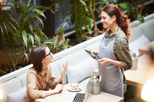 Lady asking waitress about dessert - Stock Photo - Images