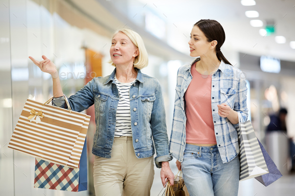 Blond lady recommending clothing store to daughter - Stock Photo - Images