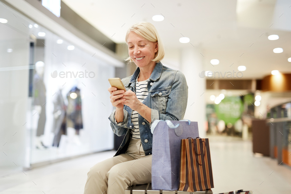 Happy woman making post about shopping on social media - Stock Photo - Images