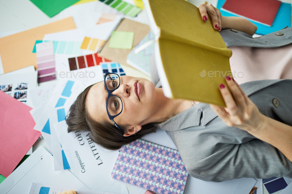 Businesswoman Reading Book on Floor - Stock Photo - Images