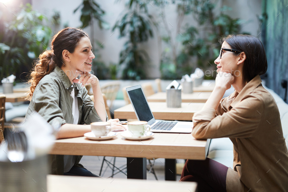 Business ladies discussing project in cafe - Stock Photo - Images