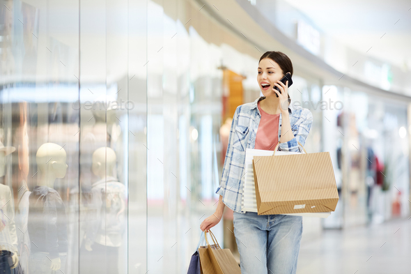 Shocked lady shopaholic talking on phone - Stock Photo - Images
