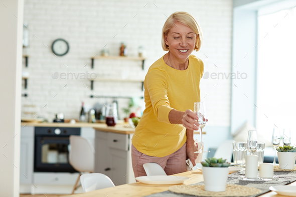 Smiling woman putting flute on table - Stock Photo - Images
