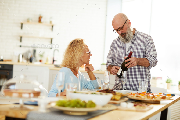 Senior man talking about wine to lady - Stock Photo - Images