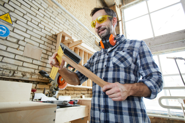 Cheerful carpenter using triangle ruler - Stock Photo - Images