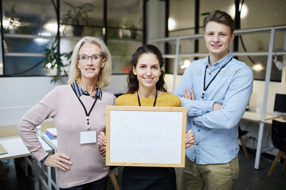 Positive colleagues presenting project using banner - Stock Photo - Images