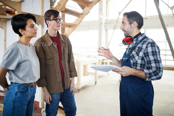 Builder talking to customers - Stock Photo - Images