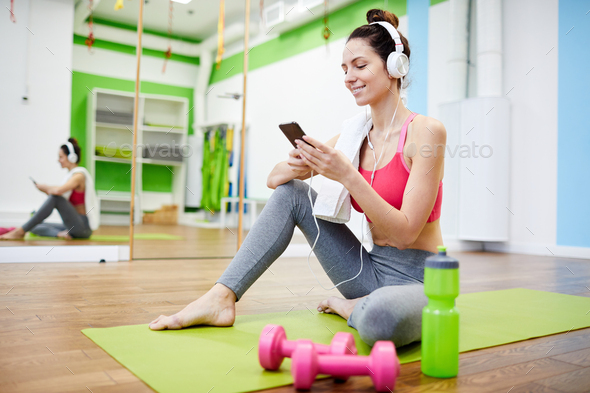 Woman Using Smartphone in Gym - Stock Photo - Images