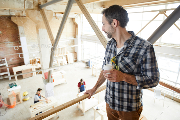 Chief carpenter observing work of joiners - Stock Photo - Images