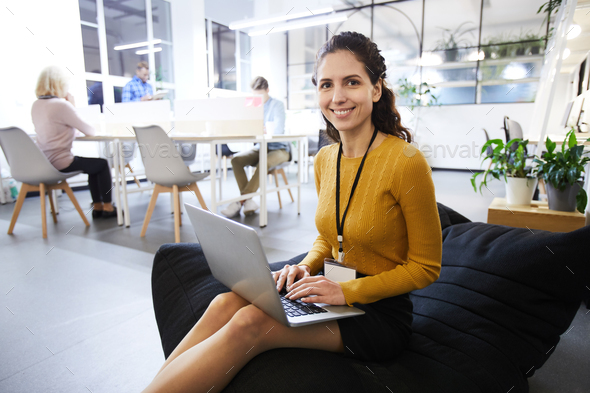 Beautiful woman with badge working in cozy office - Stock Photo - Images