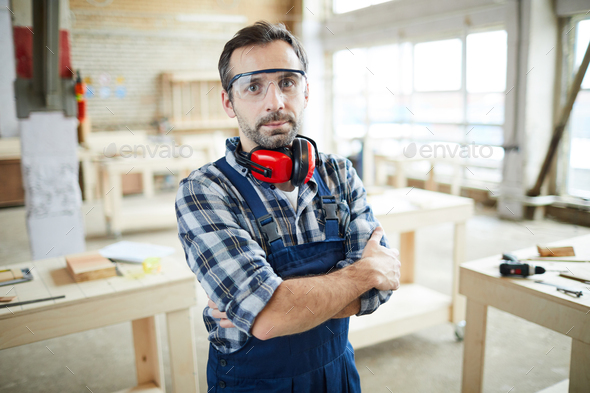Confident carpenter in protective goggles - Stock Photo - Images